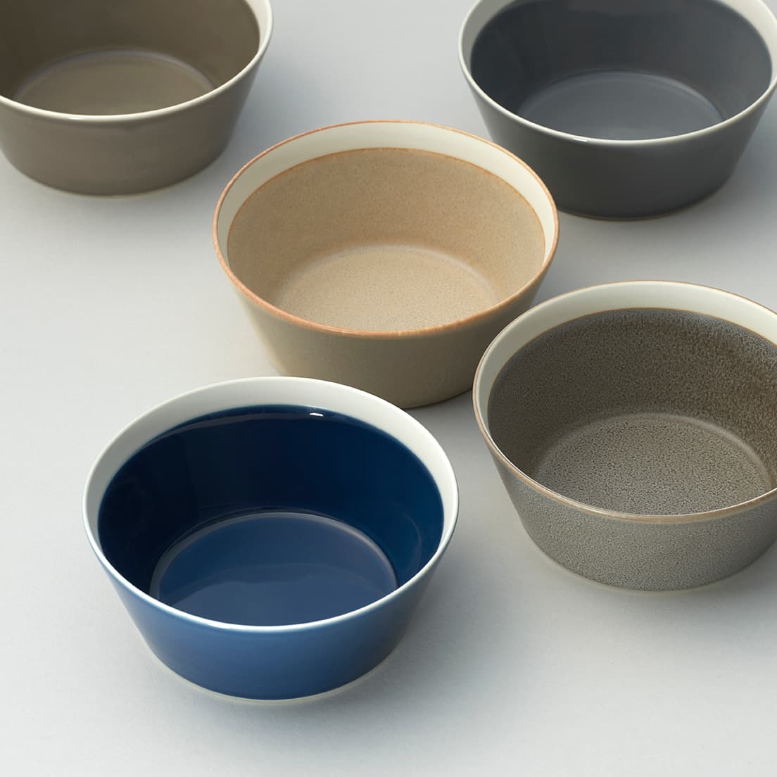 色のバリエーションも豊富な「dishes」の《ボウル Ｓ》。右上／フォググレー、右下／モスグレー、中央／サンドベージュ、左下／インクブルー、左上／ファーンブラウン。各2,420円。