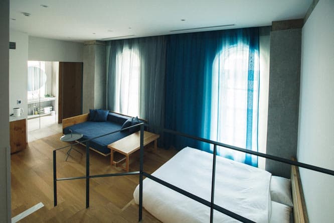 〈TSUGU 京都三条 by THE SHARE HOTELS〉　内部はその印象をそのまま活かしながらも、コンクリートをあえて象徴的に使ったスタイリッシュな空間となっている。客室は、個室タイプ9種類の全49室。一人旅からグループ旅行まで幅広く対応。