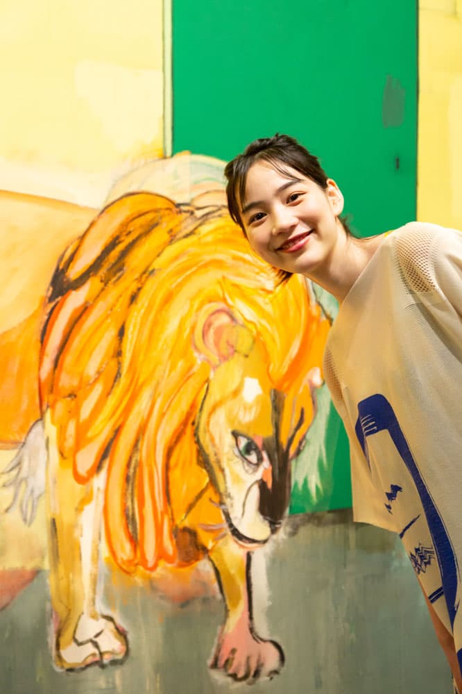 『ピーター・ドイグ展』会場の《ポート・オブ・スペインの雨（ホワイトオーク）》の前で。のん衣装：ドレス 48,000円、中に着たドレス 120,000円、シューズ 38,000円（ISSEY MIYAKE TEL 03 5454 1705）。