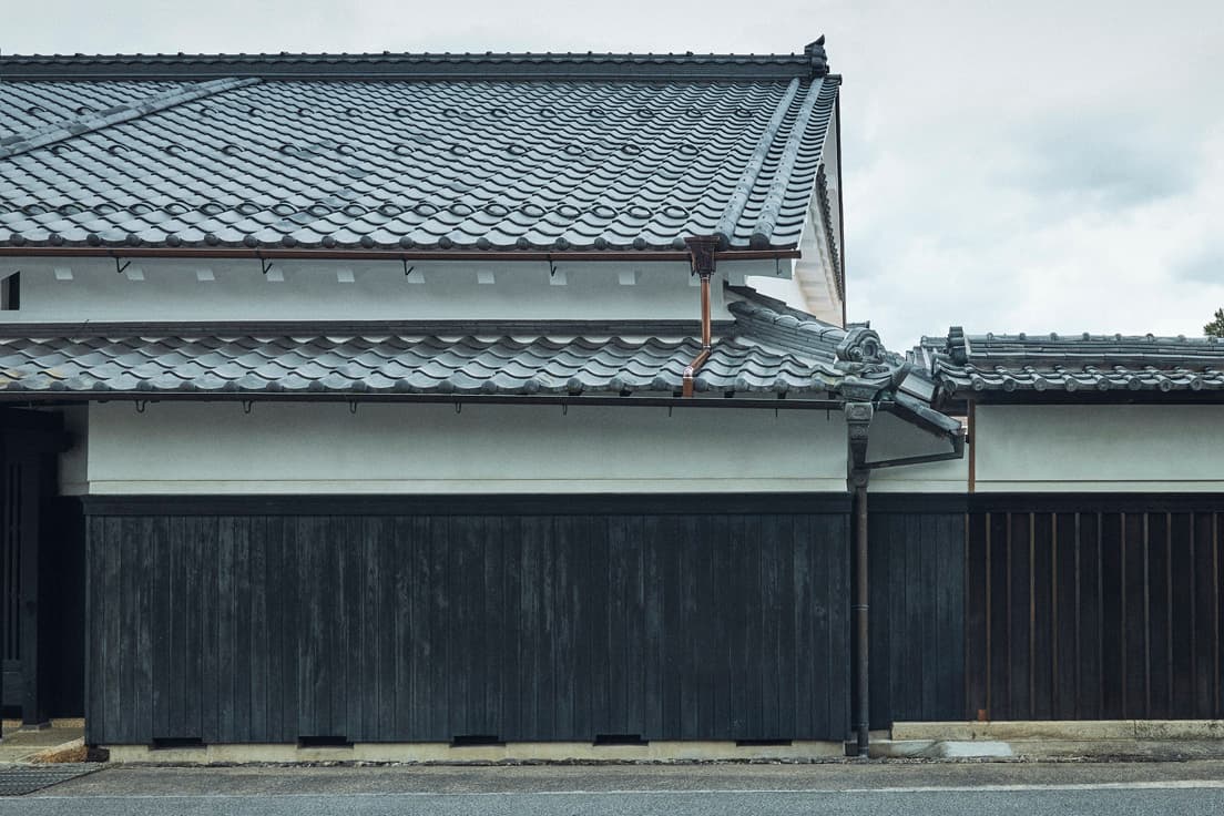 外壁はわずかに青緑色がかった白壁で、京都伏見でとれる「浅葱土」を混ぜている。真っ白い壁は格が高いので、商人の家は遠慮して浅葱土を混ぜるという習わしを踏襲した。