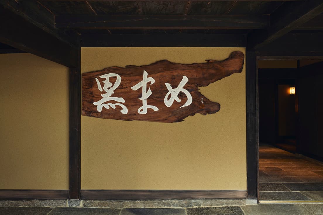 貴重な屋久杉の一枚板に杉本の筆で「黒まめ」と記した看板が客を出迎える。