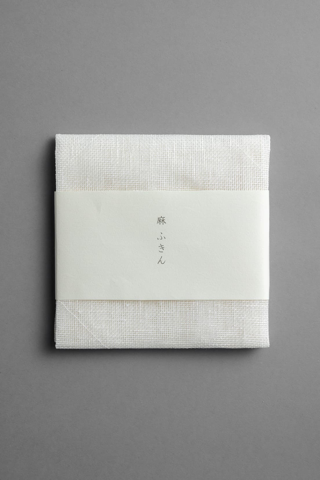 1863年(文久3年)創業の〈岡井麻布商店〉による《麻ふきん》。麻の蚊帳生地を2重にした大サイズは、端辺の中央に引っ掛け紐が付いている。「古都奈良の雪」と名付けられた真っ白なふきん。50×50㎝ 880円（岡井麻布商店 TEL 0742 81 0026）。