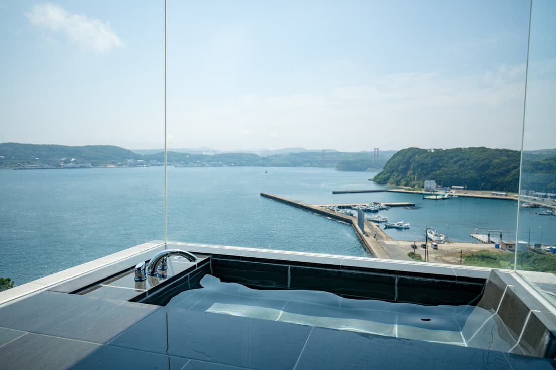 三面ガラス張りのバスルーム。湯舟につかると浮かんでいるような気分を味わえる。