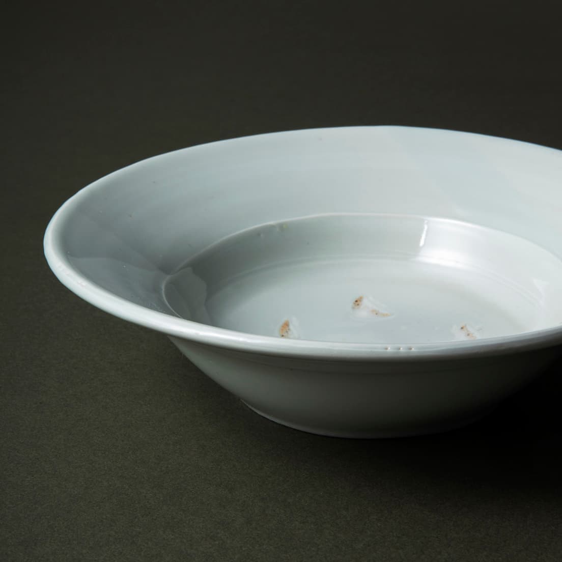 とろんとなめらかな表面に残る、針の先でつついたような“ピンホール”も味わい深い。釉薬をかける時に生地についた有機物が、高温で焼かれて小さなへこみになるという、手仕事ならではの現象だ。