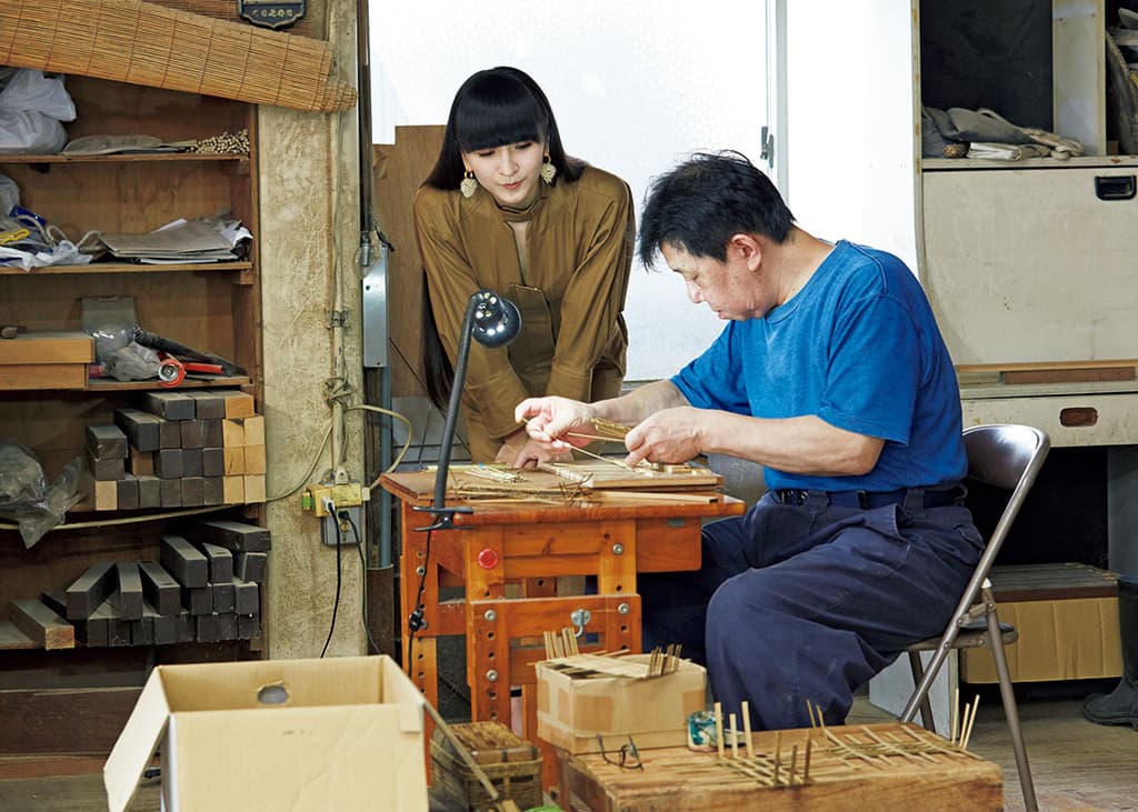 「竹工芸は寸法を守ることが肝心」と話す職人と。