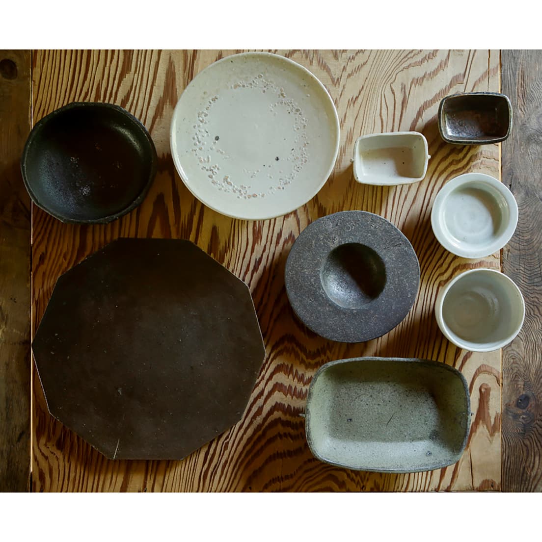 個展は京都の〈木と根〉で12月15日から。左上から反時計回りに《オンギ面取鉢》5,000円、《オンギ十角盤》直径27〜28cm  15,000円、《黒伊羅保祭器形鉢》20×13×高さ15.5cm 10,000円、《堅手カップ》4,500円、《白瓷リム豆鉢》3,500円、《オンギ角豆鉢》2,800円、《堅手耳付豆鉢》3,000円、《堅手台皿》 直径19cm  10,000円。中央は《オンギリム小鉢》直径16cm×高さ2.8cm 4,000円。展覧会情報は文末に。