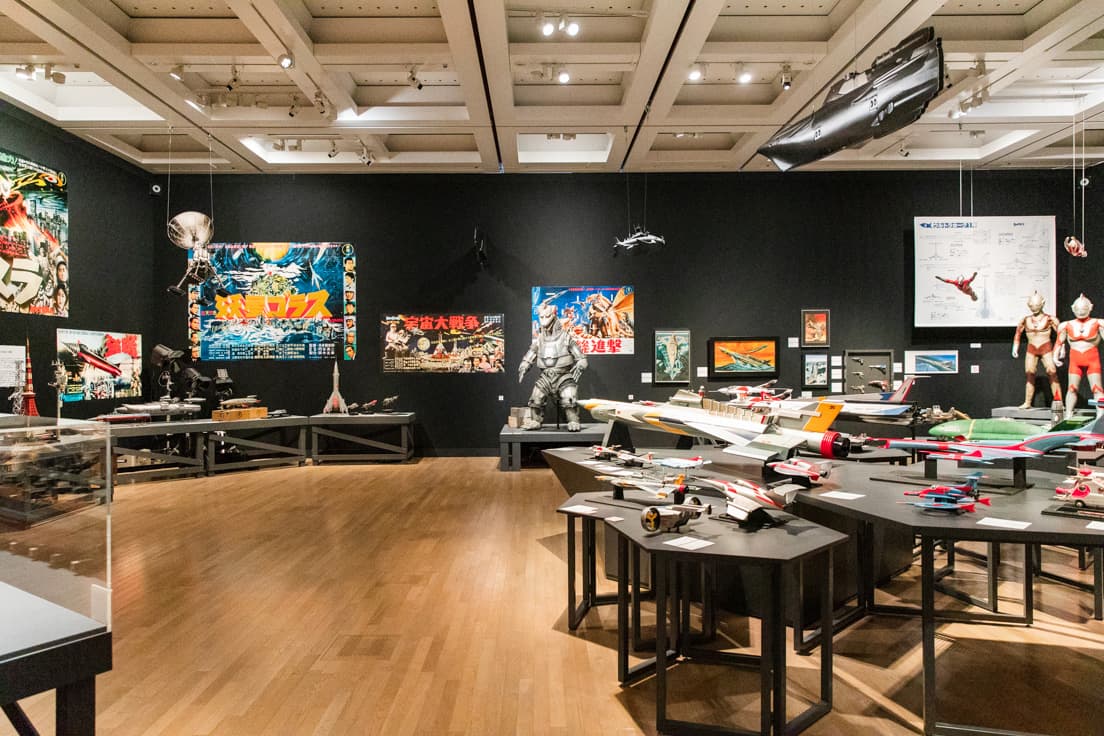 「第１章 原点、或いは呪縛」の展示風景。庵野が幼少期に熱中した漫画やアニメ、特撮の模型やポスターが並ぶ。