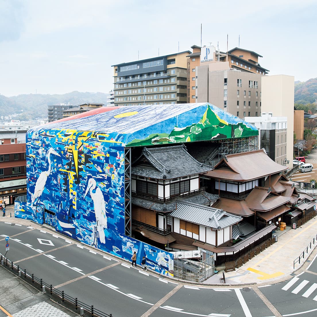 現在〈道後温泉本館〉は東面に入口を設け、〈霊の湯〉のみで営業を続ける。2024年12月までのおよそ3年にわたって工事仮設物を作品として展示。東面には愛媛県にある西日本最高峰の石鎚山を描いた。