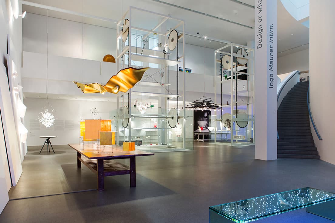 ミュンヘンの現代美術館〈ピナコテーク・デア・モデルネ〉『Design or What ?』展会場風景。2層近くある美術館の空間を、インゴ・マウラーの照明たちが縦横無尽に駆け巡る。写真中央、滑車のある展示コーナーにはプロトタイプや手がけた空間の模型などが展示され、ゆっくりと回転稼働していた。
