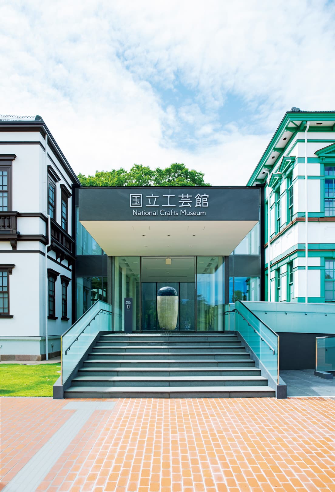 2つの建物を繋ぐエントランス。その奥にある中庭に展示されているのは金子潤による高さ約3ｍの陶磁作品で、強い存在感を放つ。