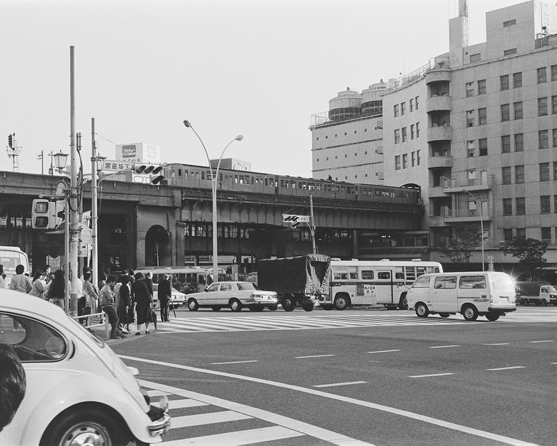 《渋谷宮益坂下1984》関東初の私鉄ターミナルデパートとして1934年〈東横百貨店〉として創業、2013年に閉店した〈東急百貨店東横店東館〉と1970年増築、2020年閉店の〈東急百貨店東横店南館〉が見える。善本は森山大道と深瀬昌久の助言に従い、当時この坂の上で写真ギャラリーを開設していた。