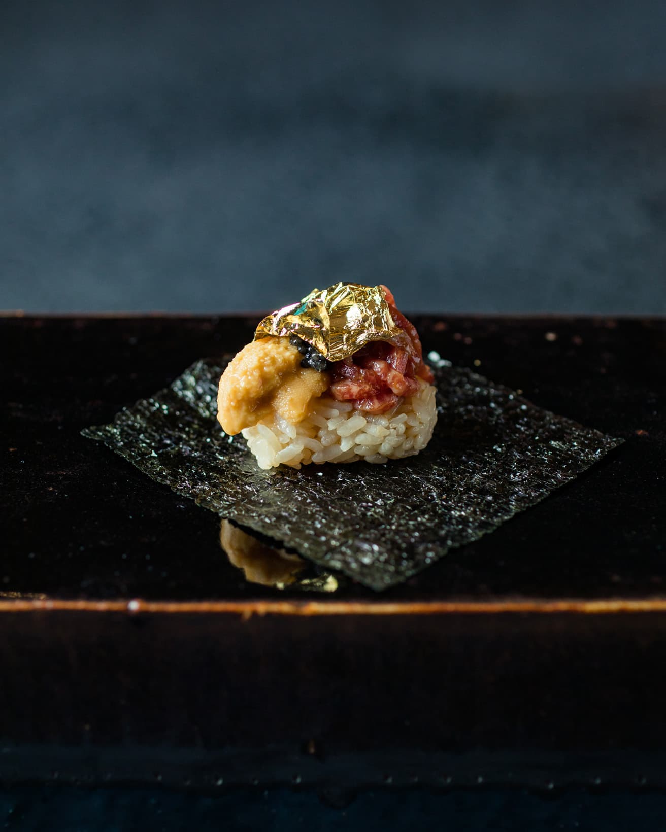 料理は月替わり35,000円のコースのみ。先附の「純但馬牛の贅沢肉寿司」。北海道余市産の蝦夷バフン雲丹と、ラトビア産フレッシュキャビアを添え、金箔があしらわれてくる。