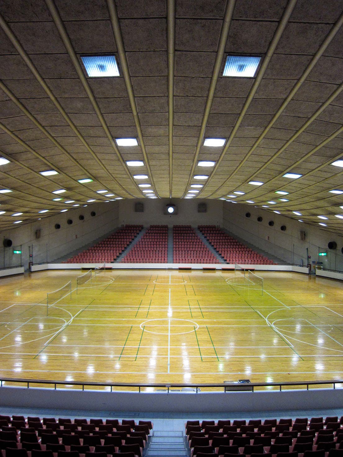 体育館内観。アリーナの天井の曲線のラインをみると、「吊り屋根構造」であることがよくわかる。