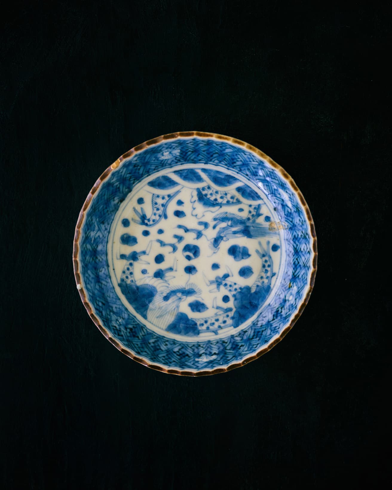 龍の繊細な絵付けが施された1枚。口に茶色の縁取りがあり、骨董ですがカジュアルな雰囲気もあり、使いやすいです。縁の立ち上がりが絶妙で、あえもの、揚げ物、豆腐などどんなものも盛りやすく、使う頻度が高い器です。