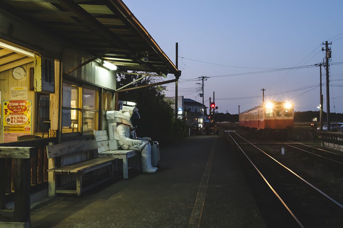 〈上総村上駅〉レオニート・チシコフ《第二の駅　村上氏の最後の飛行　あるいは月行きの列車を待ちながら》。駅のベンチにひとり腰掛ける孤独な宇宙飛行士。
