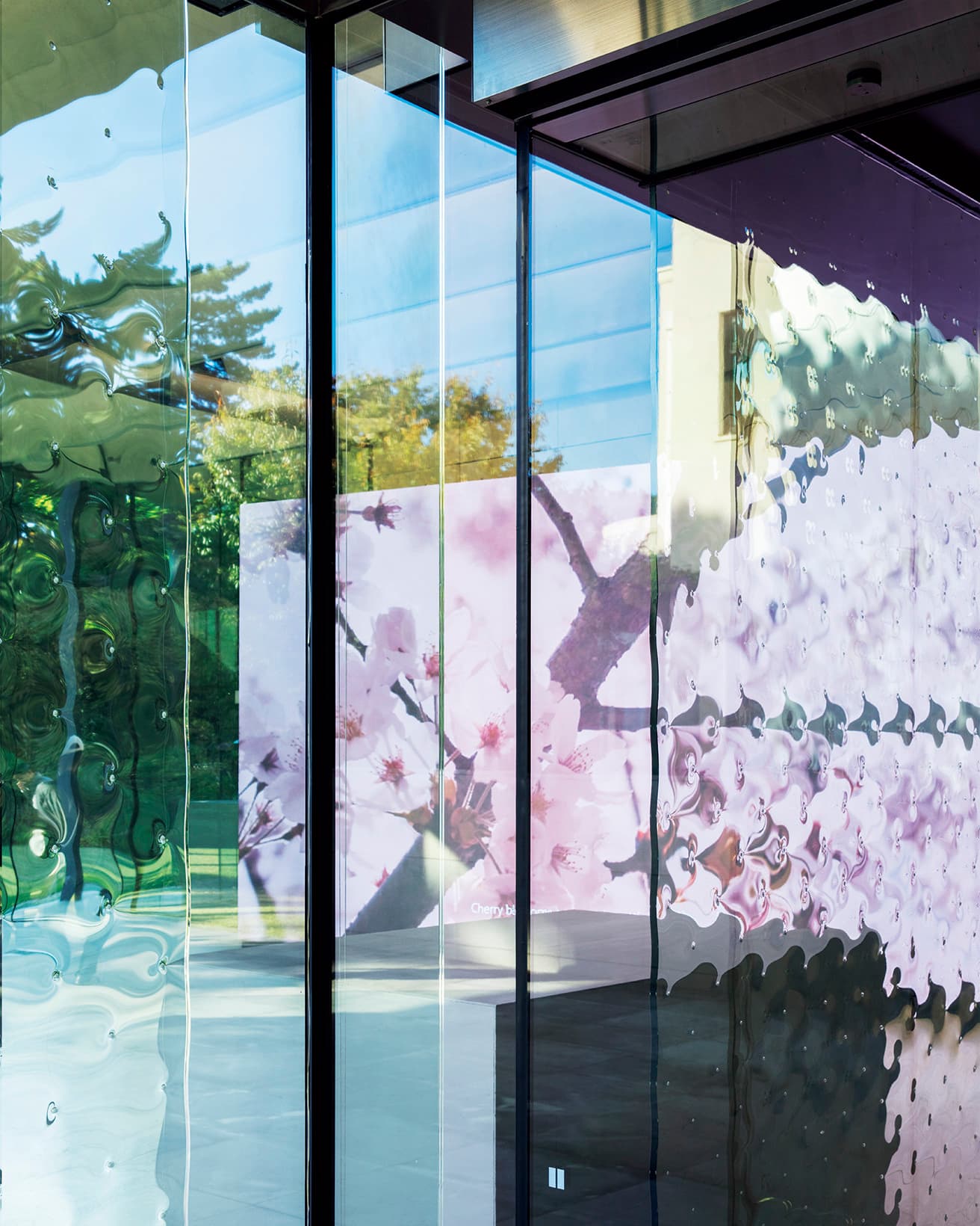 アールデコ建築の本館から、杉本博司が関わった新館に続く渡り廊下で、波板ガラス越しに作品を見る。都市や自然を通じて感性を育むAIのモノローグによる映像作品で、人に寄り添うAI独自の価値観を通じて逆説的に人という存在を描いた。
