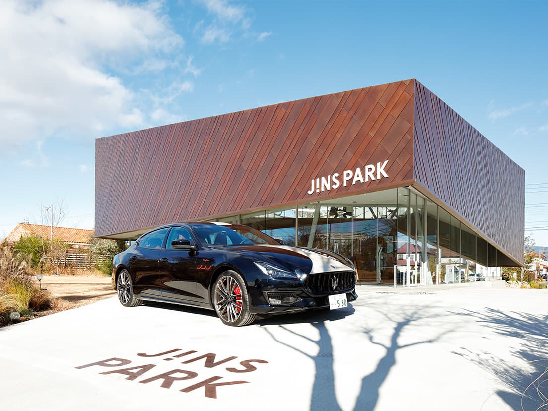 〈JINS PARK〉のエントランス側に停車する〈マセラティ〉の《クアトロポルテ》。ボンネットのレーシングストライプは《フォーリセリエ・プログラム》による特別なペイント。