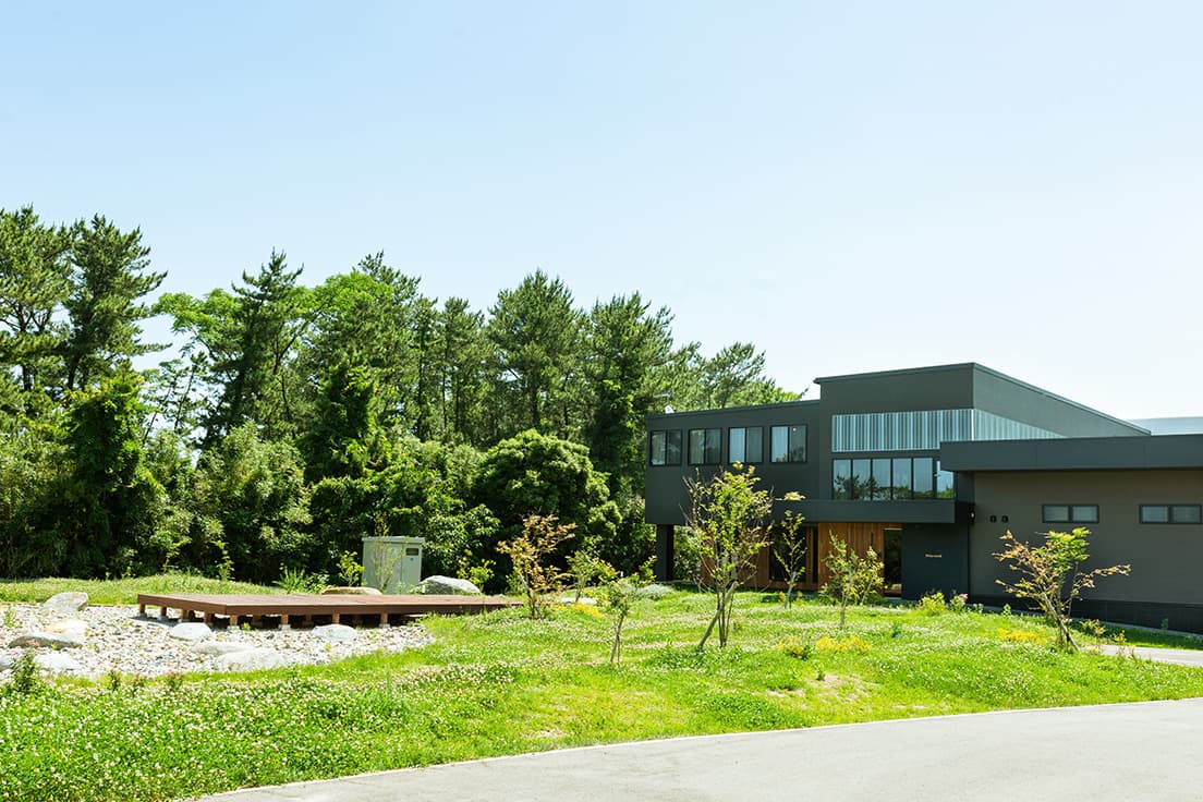 こちらは福岡県糸島市の工場。松林の向こうには砂浜、そして海が広がる。美しい環境から、美しい家具が生まれる。