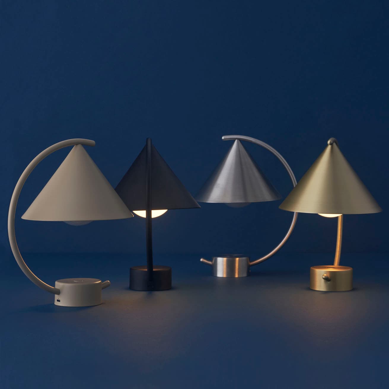 ファームリビング《MERIDIAN PORTABLE LAMP》36,300円。選べる4種類の仕上げ。左からカシミア、ブラック、ステンレス、真鍮。上記の写真は全て約50%の明るさ。サイズ：W20.9cm×D17cm×H26cm、重さ：0.7kg、素材：スチール（ステンレス、真鍮、パウダーコーティング）。5時間でフル充電、100%の明るさで12時間連続点灯。調光可（長押し）。 USBコード付属。 
