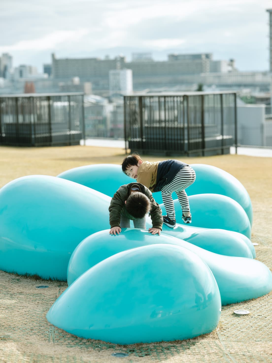 〈富山県美術館〉屋上にデザインされた〈オノマトペの屋上〉。こちらのこどもたちが遊ぶ"オノマトペ"は「ぼこぼこ」。