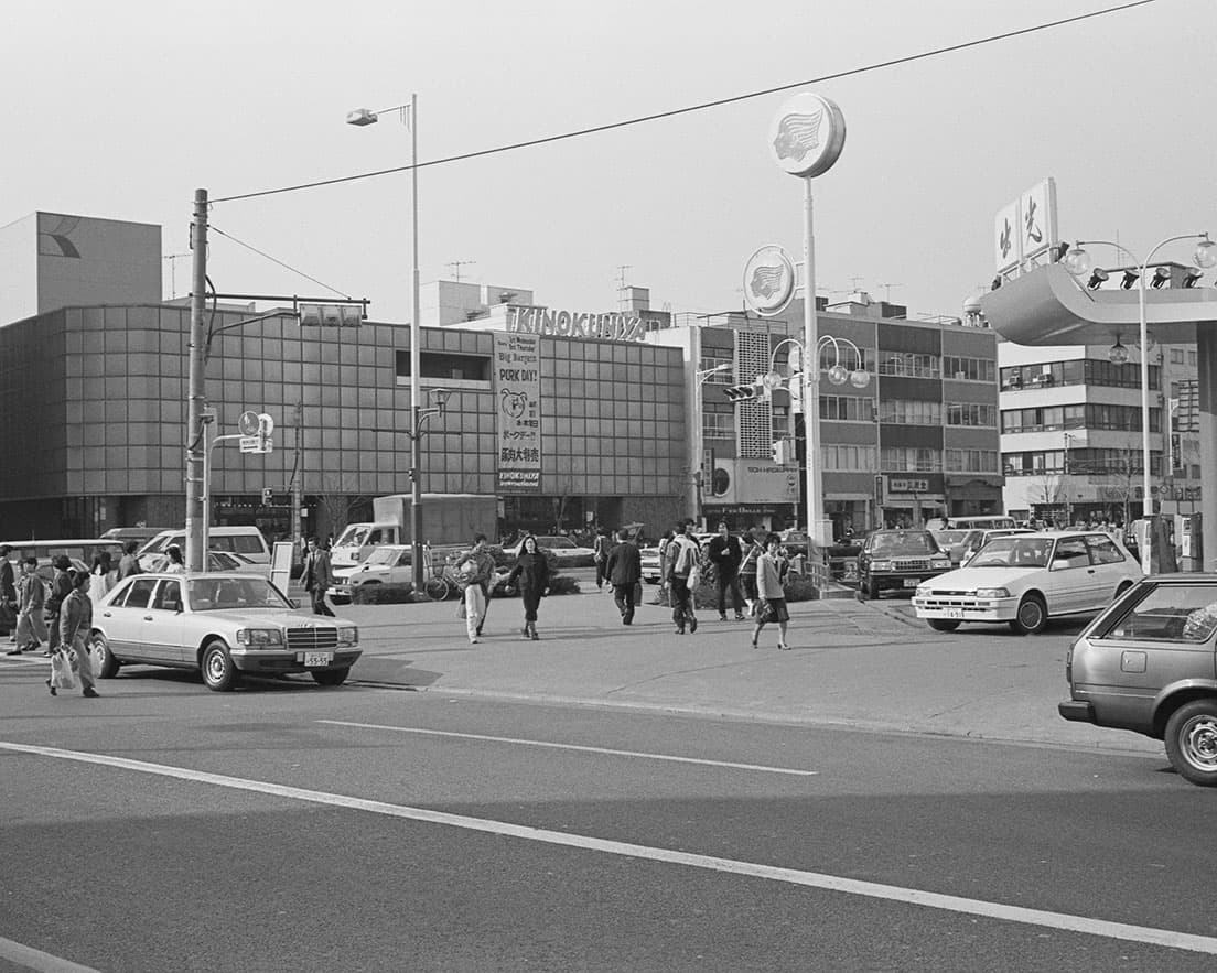 《青山〈紀ノ国屋〉1984》青山通り（国道246号）と骨董通りの三叉路にあったスーパー〈紀ノ国屋〉本店。青山通りをはさんで向かいの角には出光石油のガソリンスタンドが。
