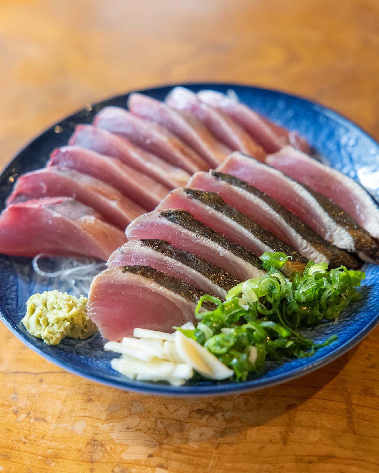 カツオのたたき（手前）、カツオの刺身（奥）。各600円〜。高知県産の青ねぎとニンニクを添えて。