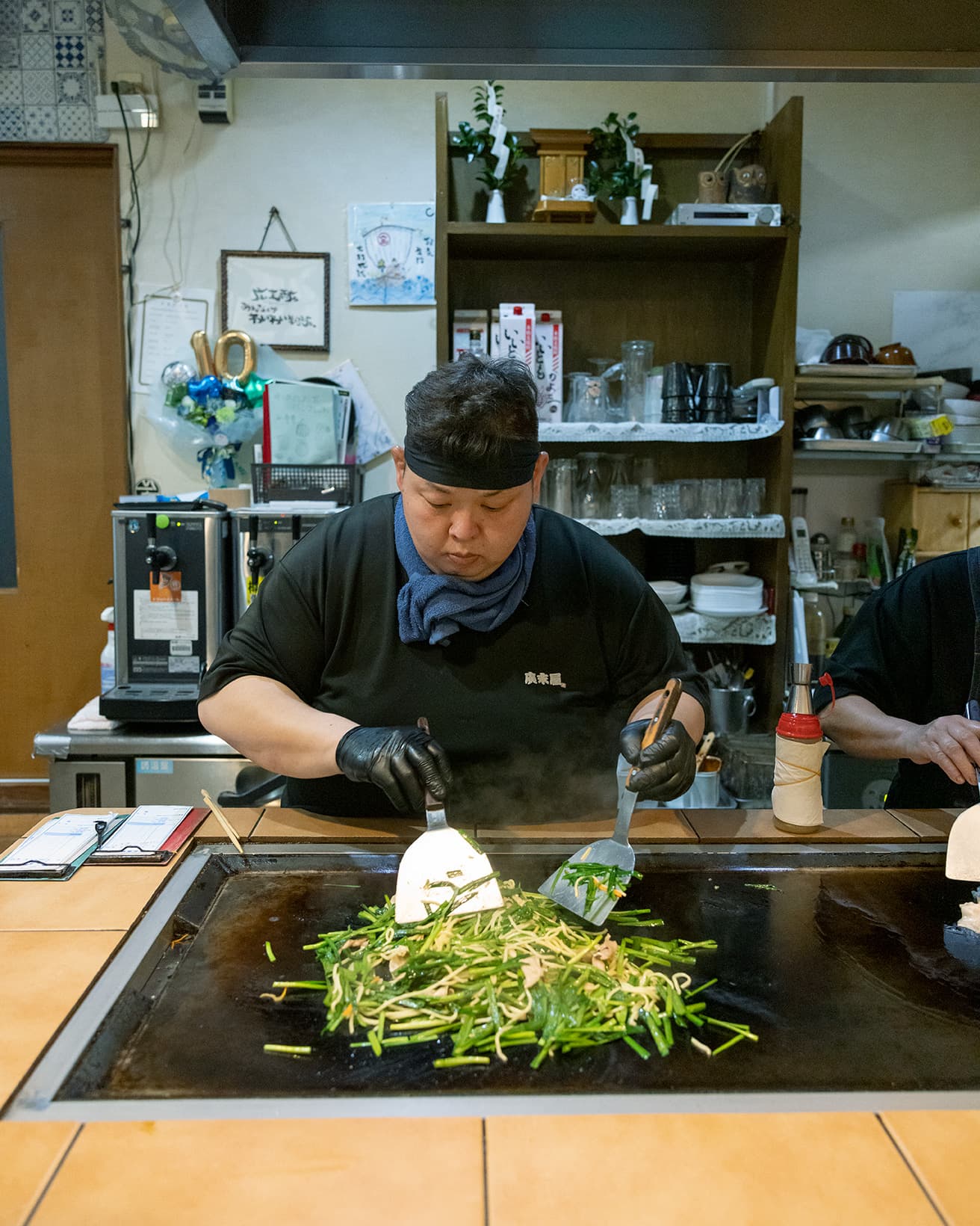 豪快な鉄板ワザ。豚バラにスルメイカ、ニラの茎→中華麺を入れてよく炒め→大量のニラを投入→塩ダレ→仕上げ炒め。