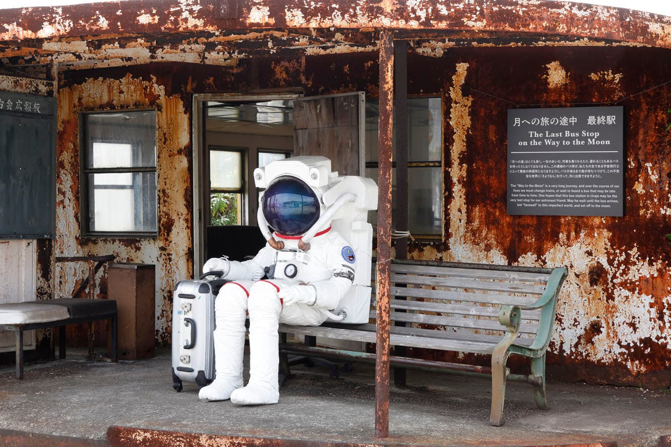 レオニート・チシコフ《月への道》、沙弥島・与島での展示。実際にバス停として使われている浦城（うらじょう）の待合で宇宙飛行士が何かを待っている。https://goo.gl/maps/yvfYo7QWfjeKbEq96　photo_Keizo Kioku
