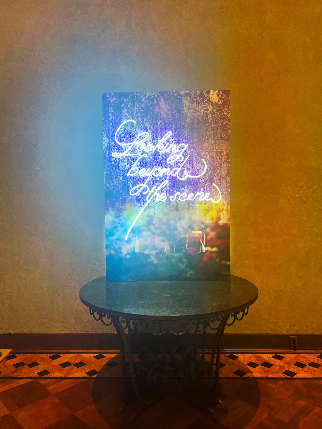 写真に、展覧会のテーマを表す「Looking beyond the scene」のネオンを配した作品。