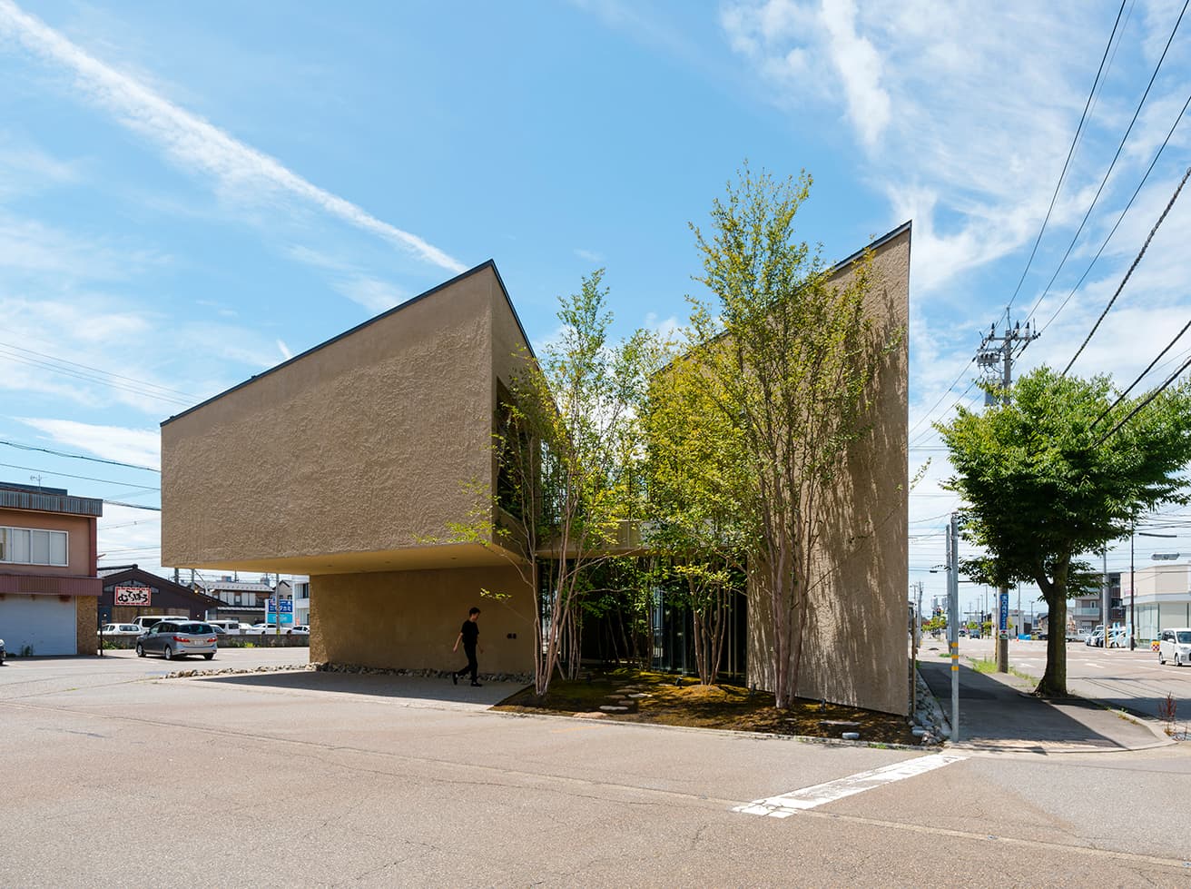 〈NODE KANAZAWA〉の東側外観。住宅、商業施設、クリニック等の設計施工から不動産販売を行う〈家元〉による複合施設。1階はカフェレストランやギャラリー、2階はオフィスが入る。建物の東西方向に茶室の露地を思わせる緑道、南北方向に城下町の金沢に散見される細い路地が走る。クライアントの自社施工で、木造の技術力を提示するために5ｍに及ぶキャンティレバー構造を採用。構造設計はオーノJAPANの大野博史に依頼した。