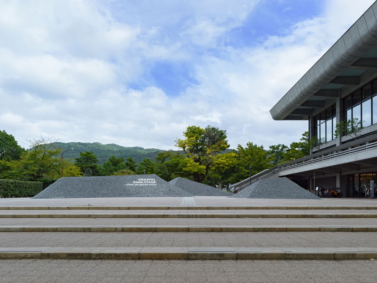 〈ロームシアター京都〉の東山をのぞむ中庭に築かれた〈石ころの庭〉。やわらかい緑とシャープな石組が対比する。