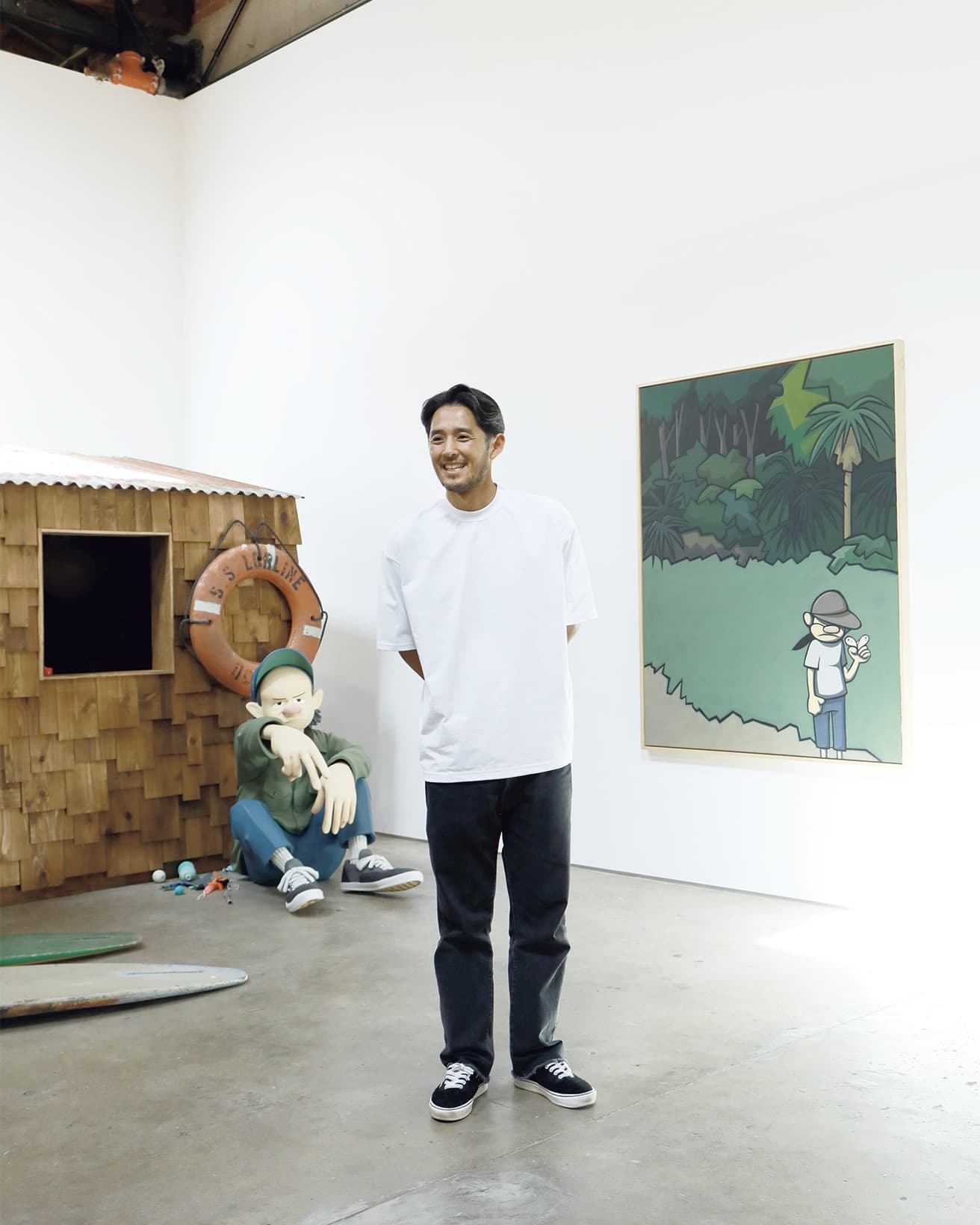 彼の展示には欠かせない海小屋をバックに佇む花井祐介。
