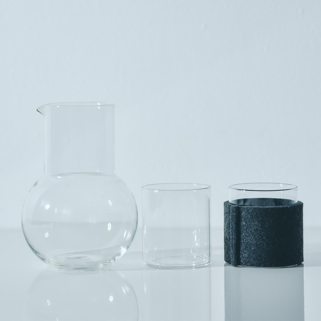 〈スタジオプレパ〉オリジナルピッチャーφ11×開口部φ6.8×H15cm(500ml) 9,350円（BTR TEL 03 3454 3786）。〈ボロシルヴィジョングラス〉《ボロシルヴィジョングラス S》φ65×H70mm(210ml)968円、《フェルトスリーブ65グレー》968円（VISION GLASS JP / 國府田商店株式会社 TEL 050 3597 6852）。