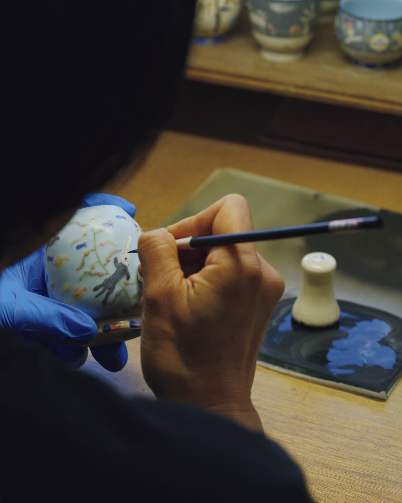 色化粧土で下地塗りした器に、さまざまな生き物が共生する世界を、ひと筆ずつ手描きする。下描きはなし。作れるのは1日2点ほど。
