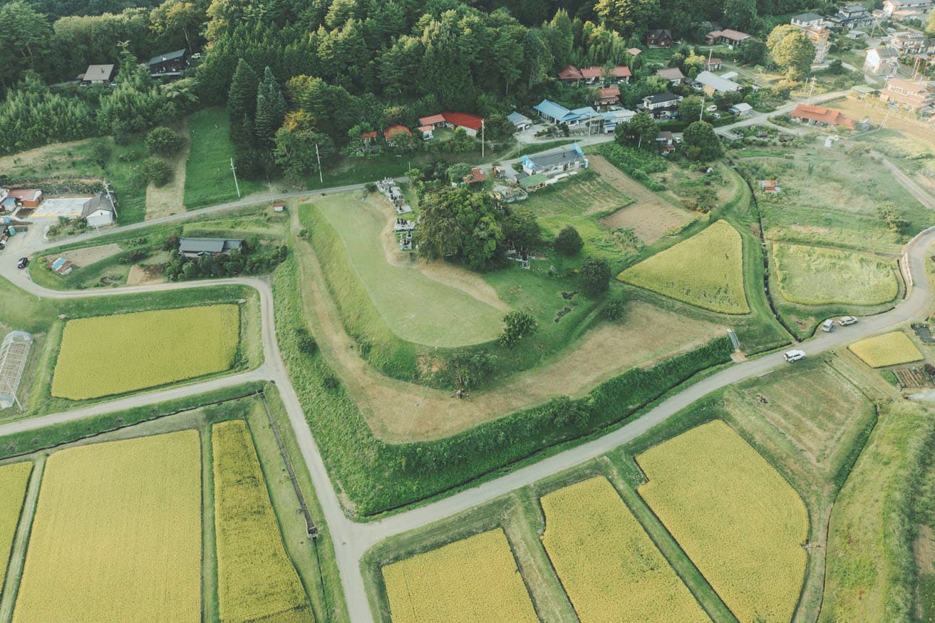 敷地は2段に分かれた棚田跡で、下段の白いロープに挟まれた突端が建設予定地。　photo_Shuhei Tonami
