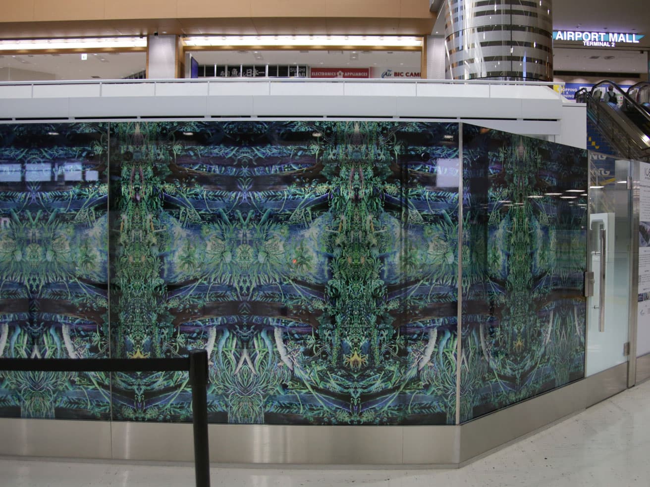 大小島真木《Narita Airport Christmas Art 2022 Yule（ユール）〜再生の祈り〜》。成田国際空港第2ターミナル本館保安検査場前のガラス面を使ったウインドウアートで、 透明シートを用いている。