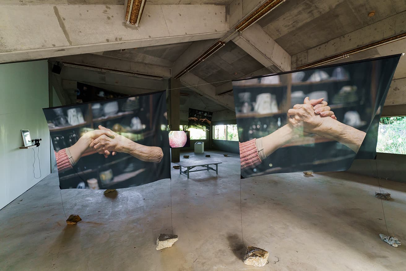 六田原展望台には、SIDE-CORE×KOM I×新美太基×KINJOによる《Spool of Time》の展示が。写真はKOM I（コムアイ）による作品《切れても切れても、結ぶことを》。大宜味村の無形文化財である芭蕉布の製作過程から着想を得て、自身の体を用いた作品シリーズを発表。