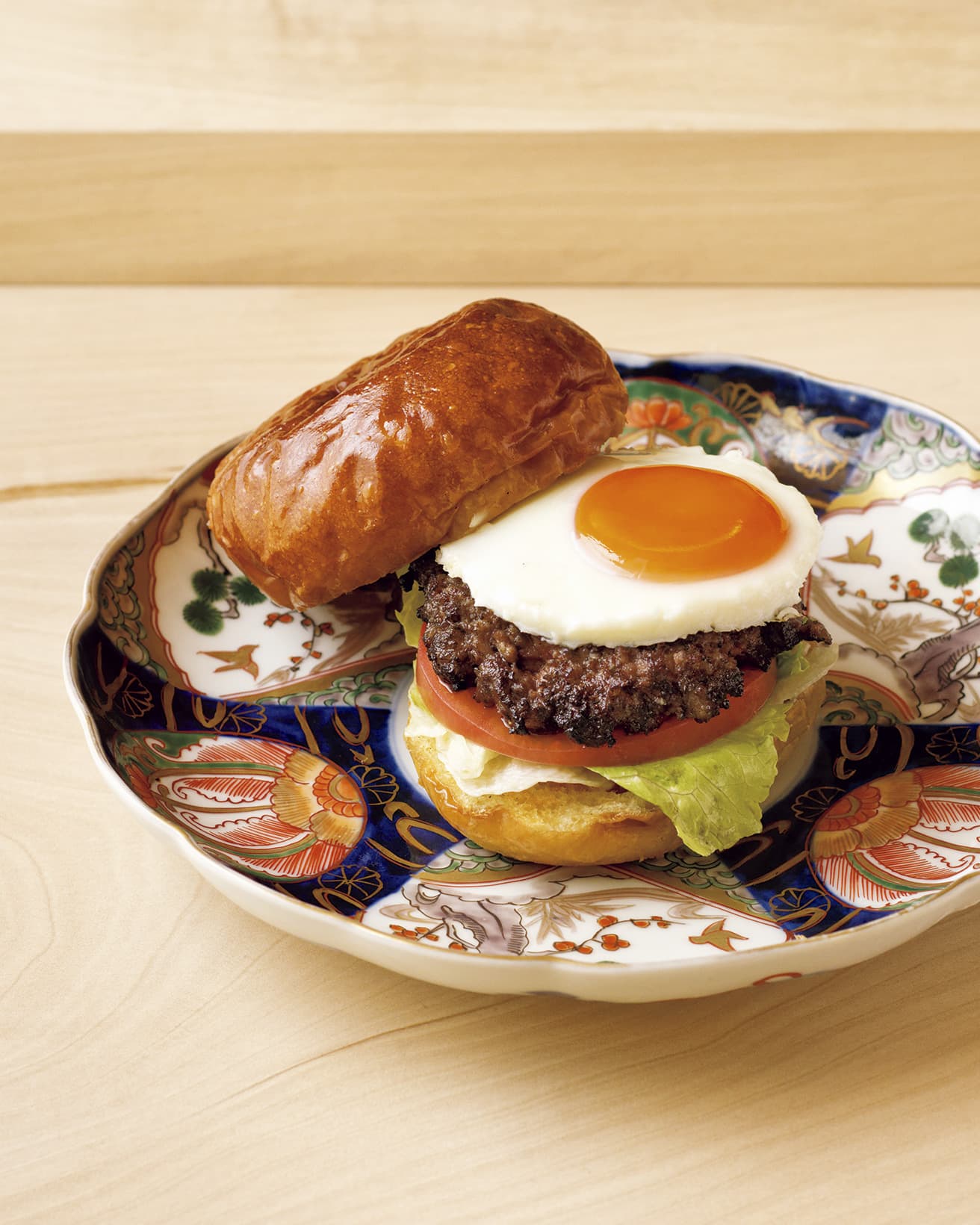 薪焼きハンバーガー（6,000円のコースの一例）。具材はパティ、卵、レタス、トマトとシンプル。