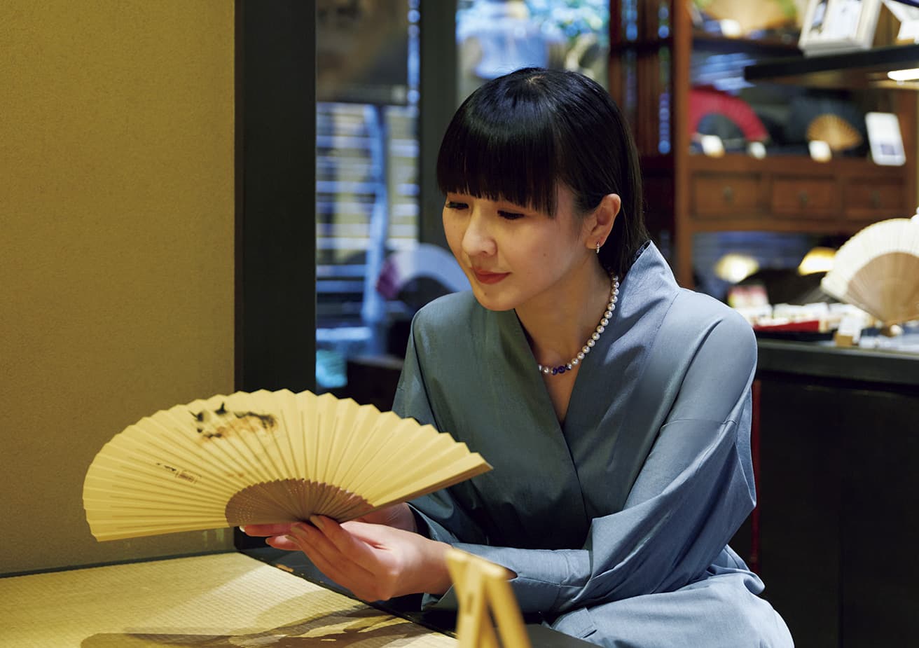 Fixated by a fan bearing the image of “Three Cats” by Takeuchi Seihō, regarded as a master of Kyoto’s traditional painting style.