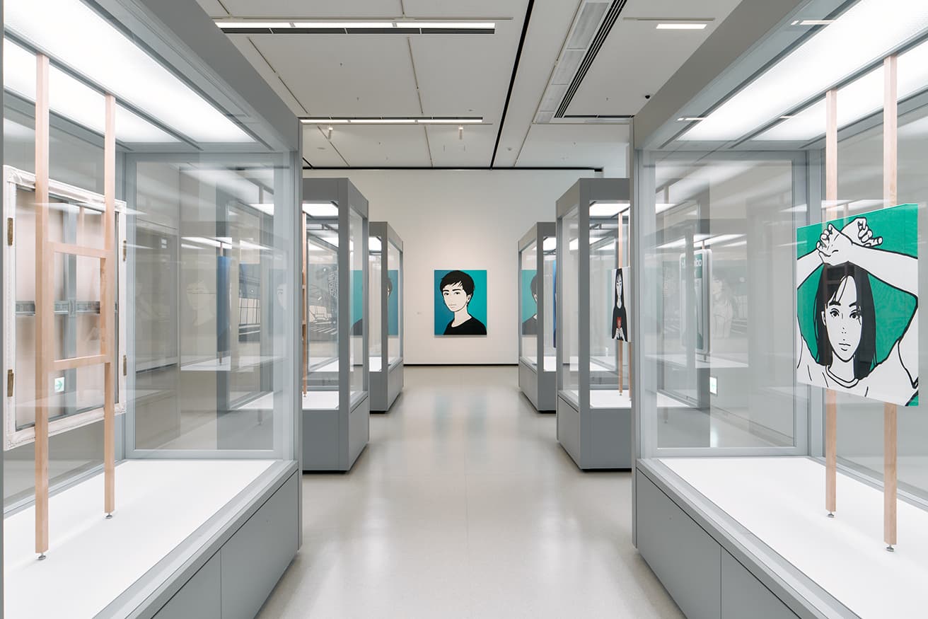 2017年から2022年までの平面絵画を展示したzone1。美術館所有のガラスの展示ケースに絵画作品を1点ずつ陳列。その合間からはこちらにまっすぐに視線を向ける女性と目が合う。