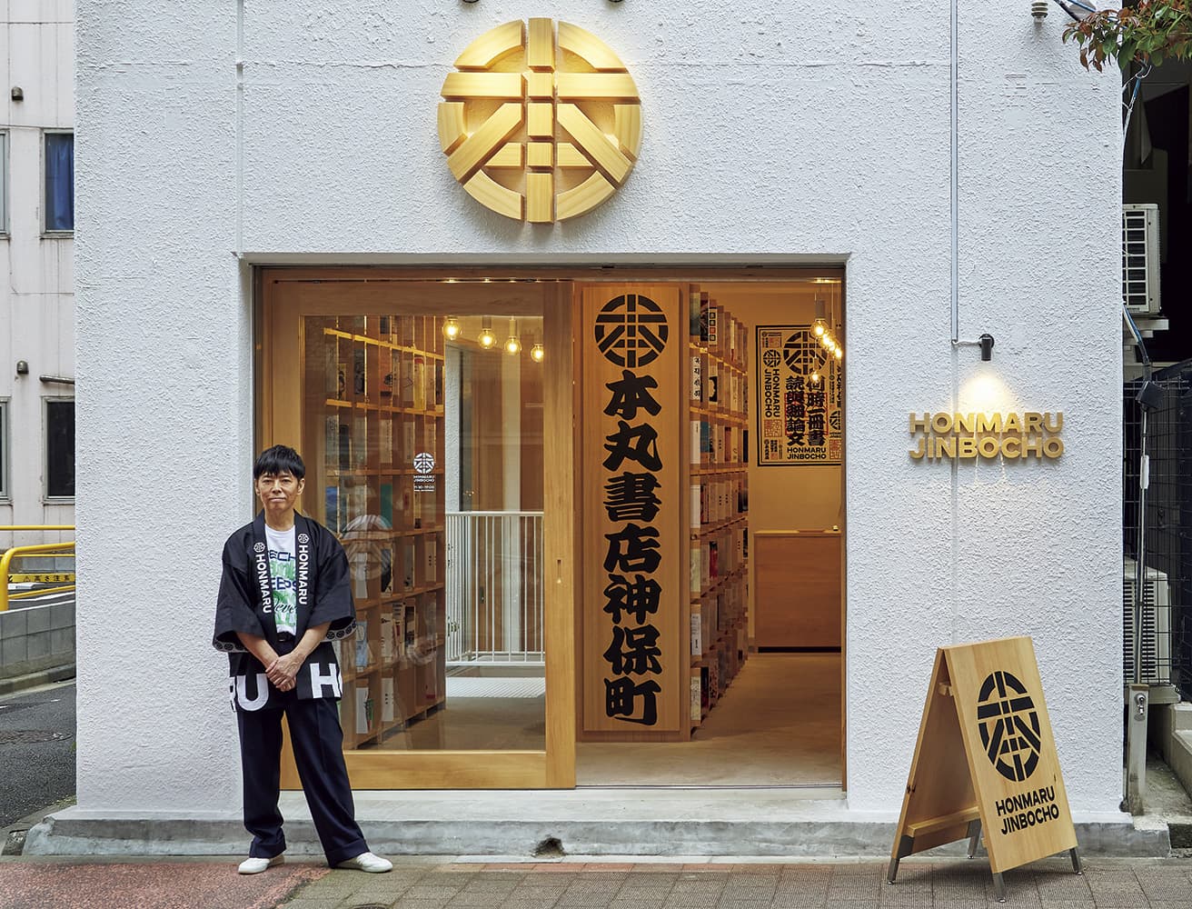 靖国通りから一本入った路地に開店した〈ほんまる〉店頭に立つクリエイティブディレクター佐藤可士和。店舗からグラフィックまで、トータルにブランディングした。