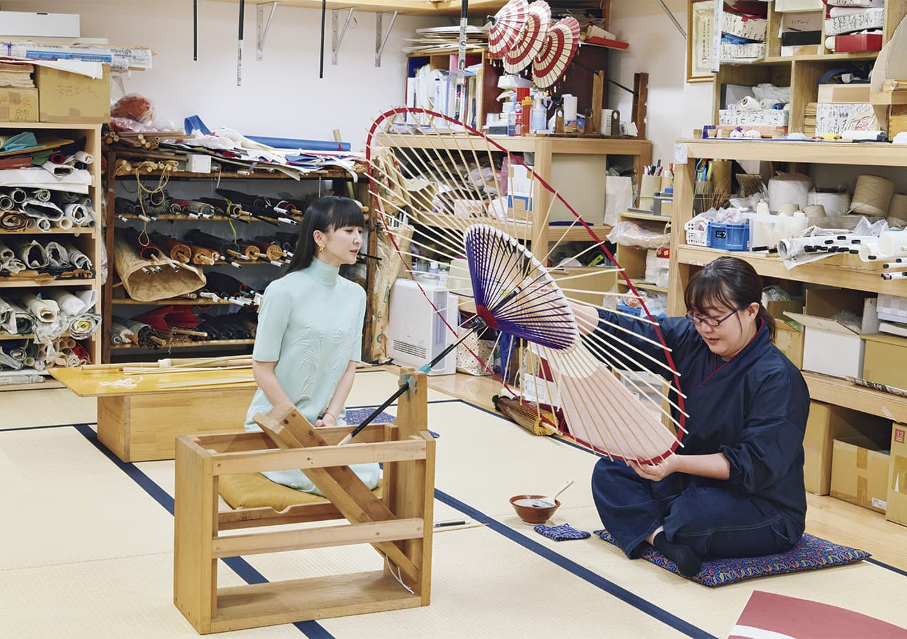 糊を塗った骨の上に和紙をのせ溝つきのヘラでこすることで和紙のよれを除き、骨に密着させる。