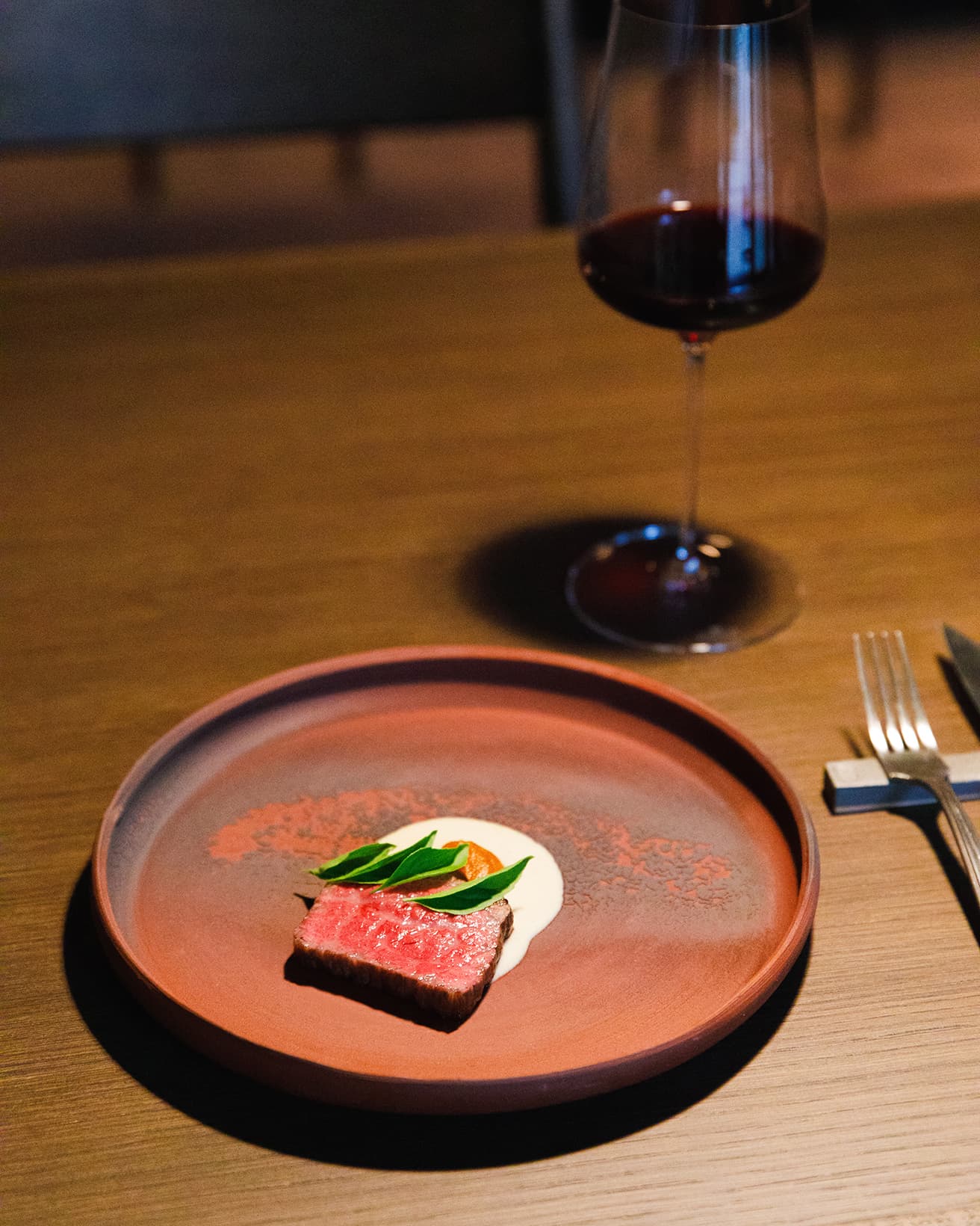 焼きナスのソース、アナトーシードのジャムを添えた炭火焼きの和牛。