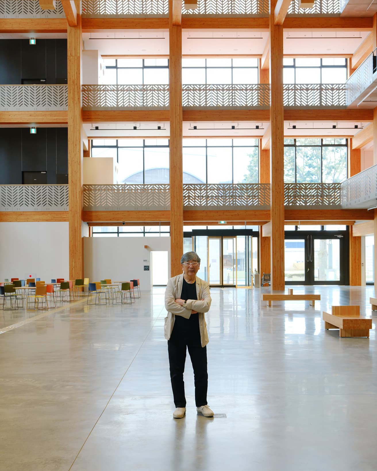 4層分の吹き抜けが気持ちいい〈水戸市民会館〉の「やぐら広場」に立つ伊東。木造空間の可能性を感じさせてくれる。