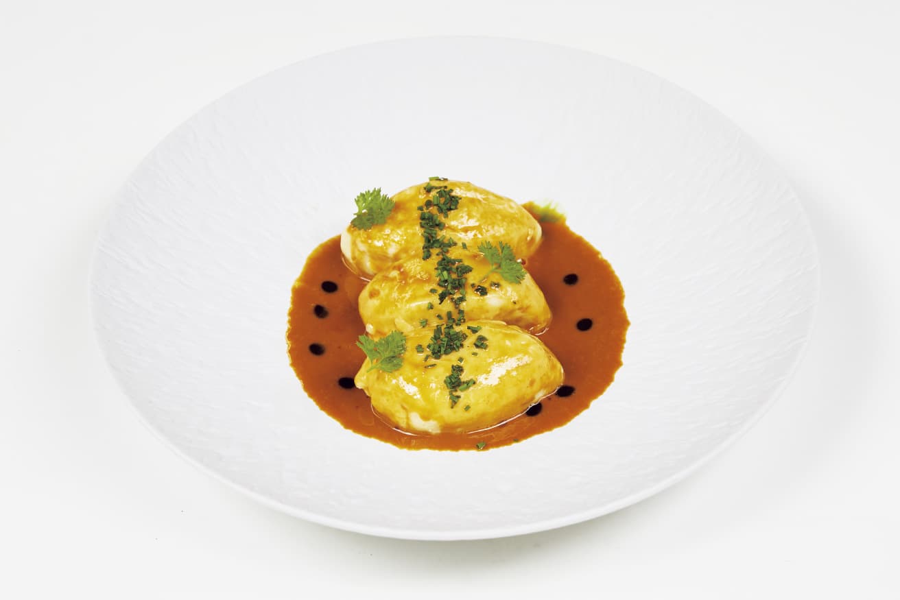 白身魚のクネル ナンチュアソース（写真の料理はランチコースのレジョナルメニュー7,500円〜の一例）。リヨンの伝統料理の一つで、ソースではロブスターの殻を炒めた甘味とコクが堪能できる。photo_Masanori Kaneshita