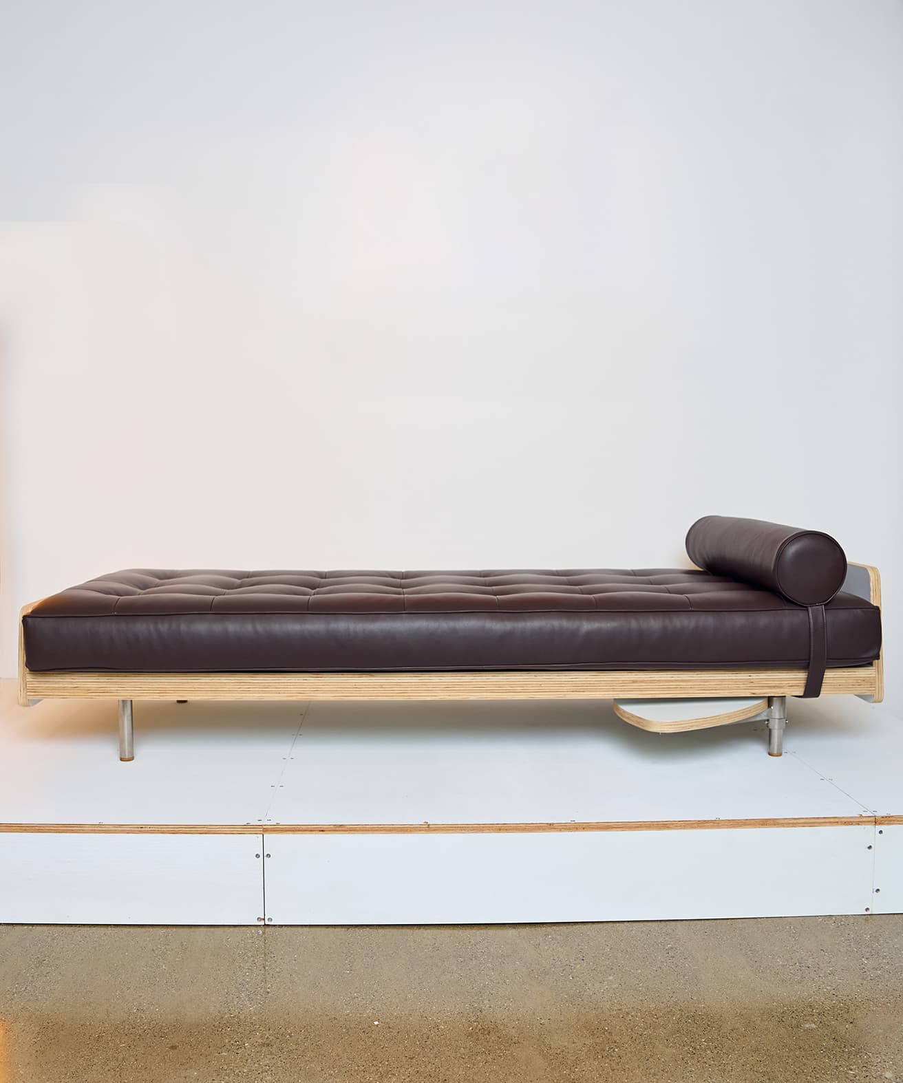 ステンレススチールとプライウッドのフレームにレザー張りのクッションを施しました《DayBed》。円筒形クッションと可動式のテーブルも装備されてございます。w190.5×d80×h49.5cm ©️Tom Sachs