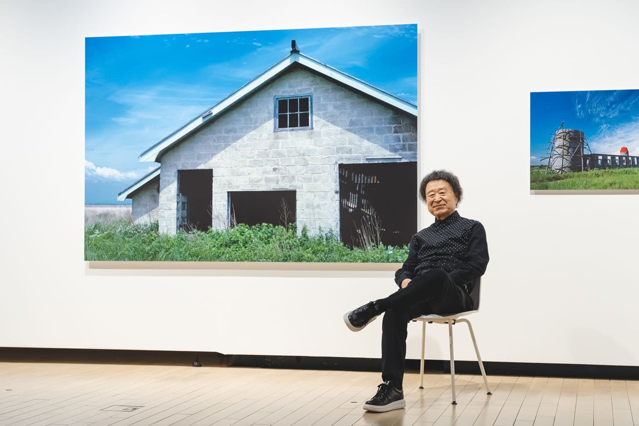 〈東京都写真美術館〉の『新・晴れた日　篠山紀信』展にて。背景の写真は「晴れた日」シリーズの《北海道苫小牧市勇払》（1974年）。