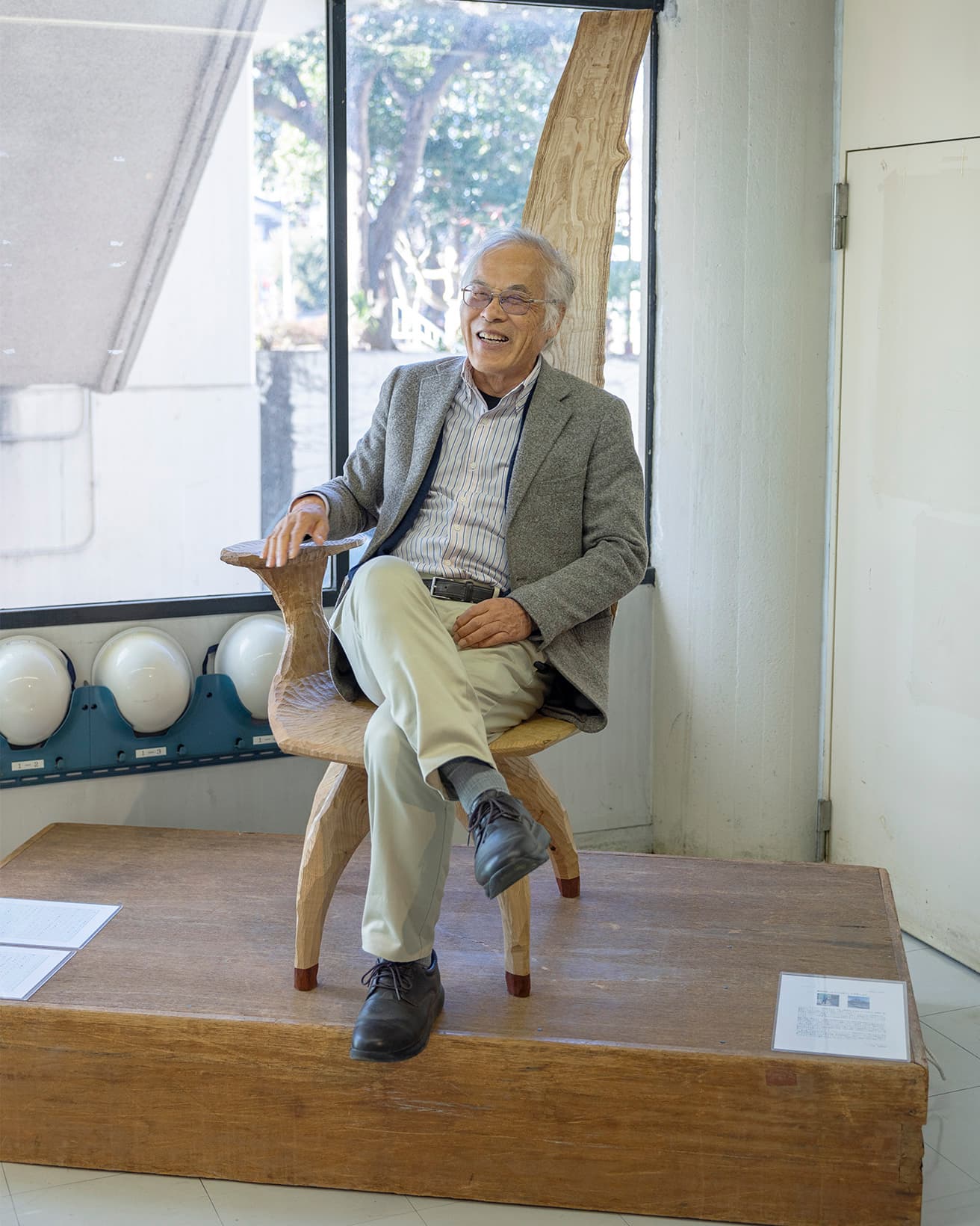《脱NW椅子》に座る藤森照信。座る人と一体化する椅子だ。