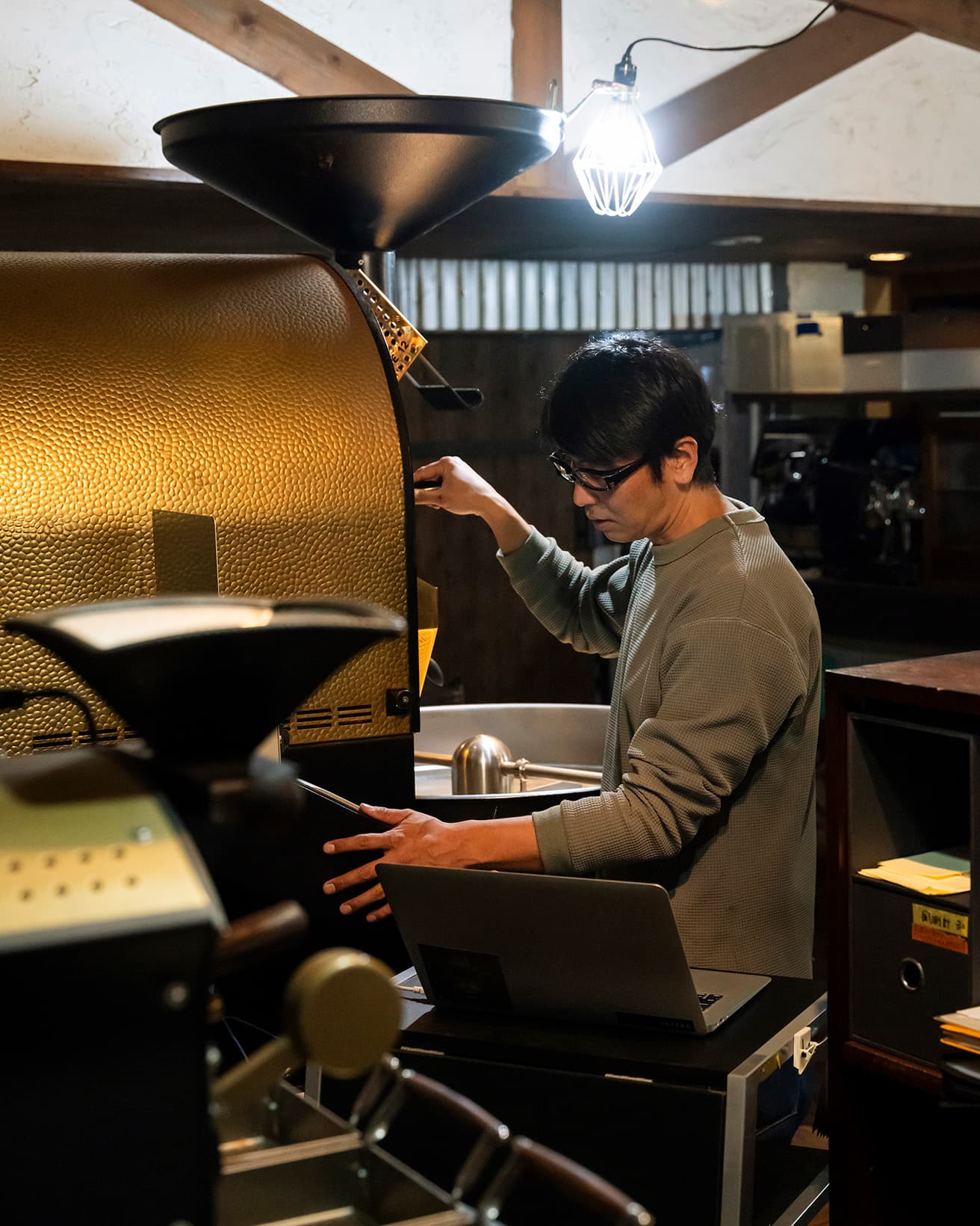 メインのロースターで作業するオーナー兼ヘッドロースターの仲村良行さん。店内には家庭用の卓上焙煎機も含め、6種類のロースターが。ここにないものも多いという。