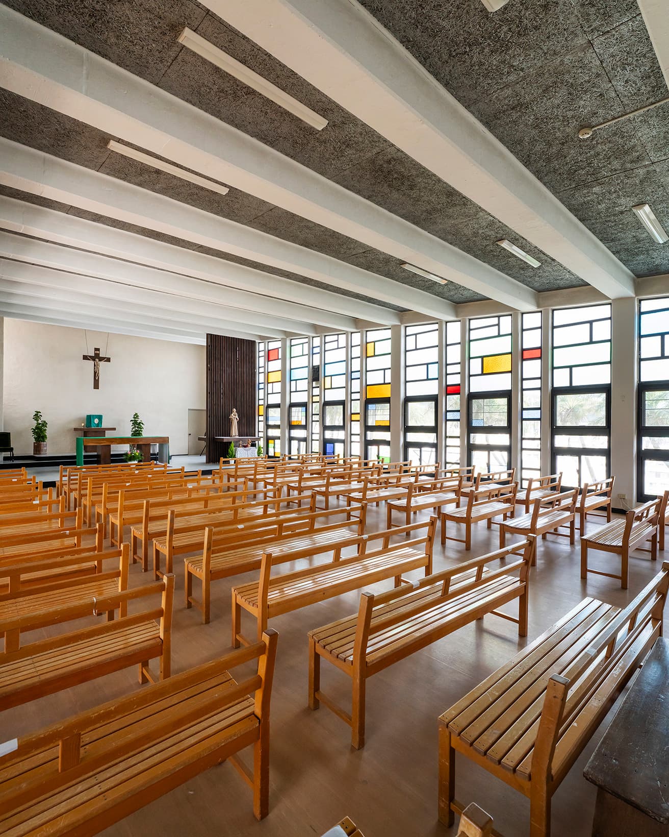 祭壇に向かって天井が高くなっている。屋根を複数の梁が支える。photo_Wataru Oshiro